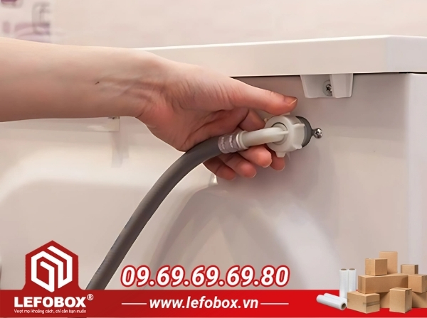 Tháo ống cấp nước trước khi đóng gói máy giặt
